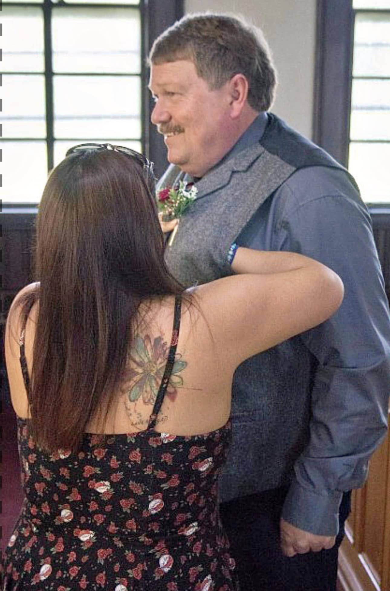Katy helping pin a boutonnière on the groom